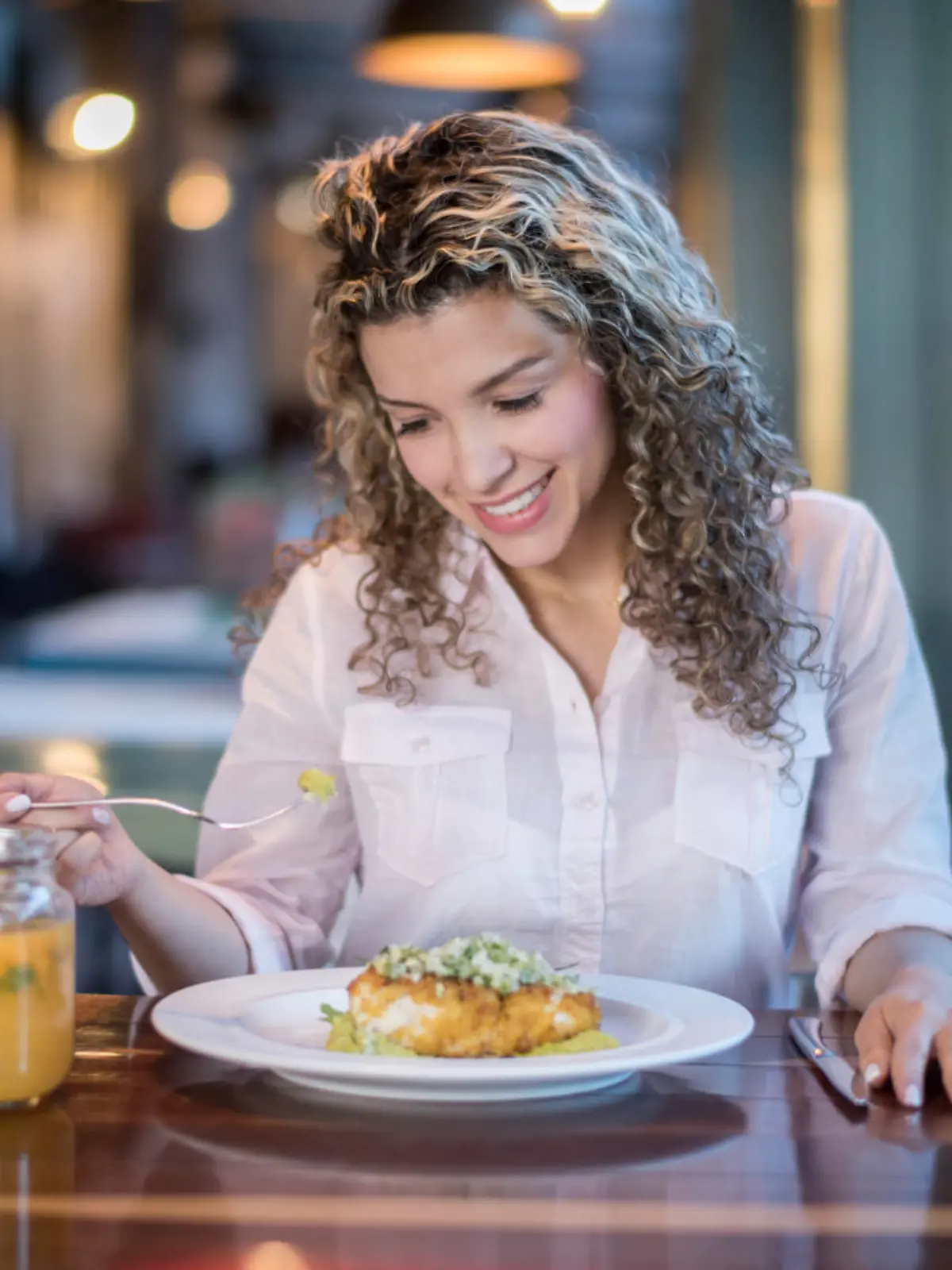 Latin American woman eating dinner alone at a restaurant - food and drinks concepts