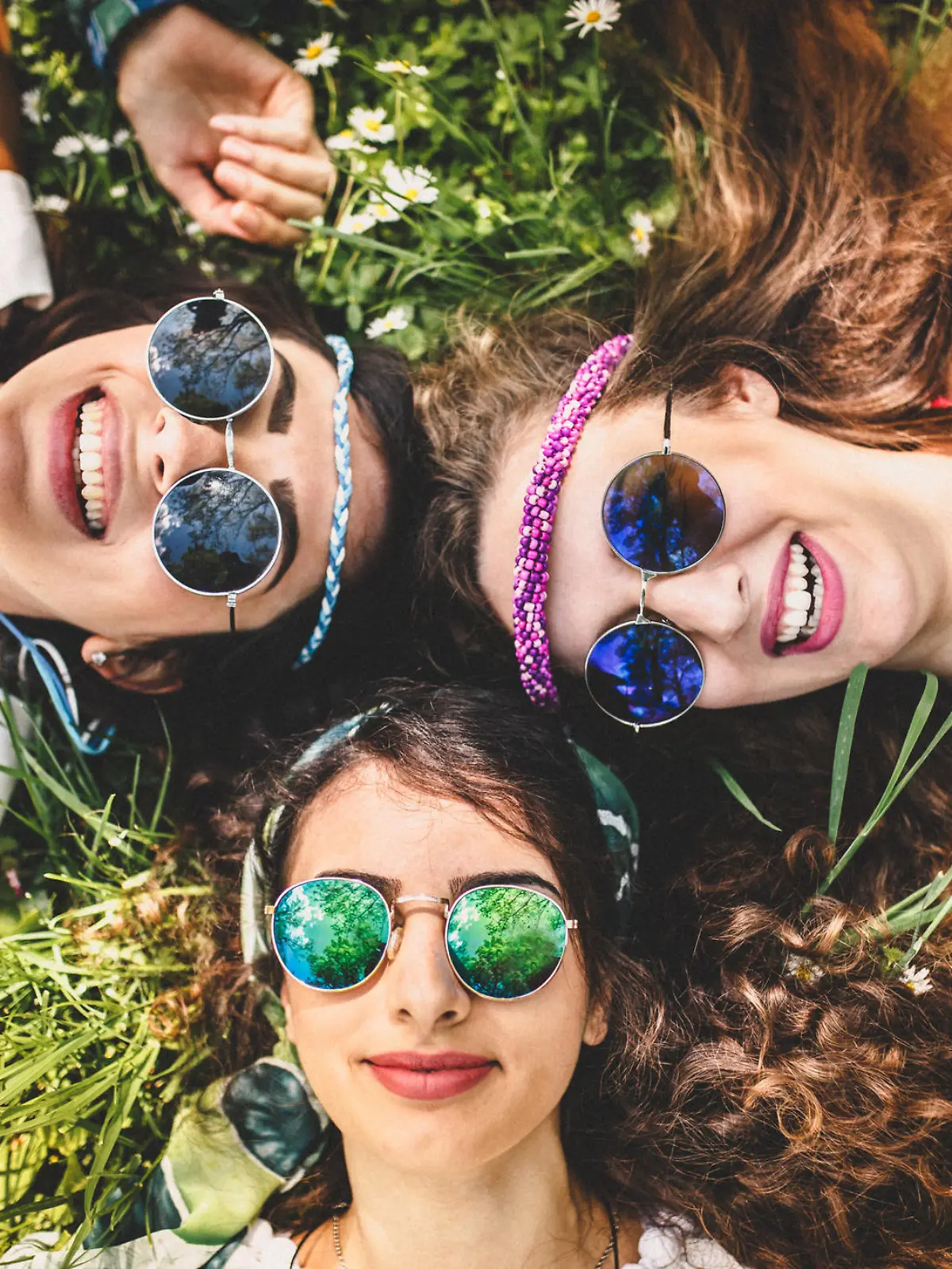 Beautiful girls of hippie laying on the grass and daisy flowers