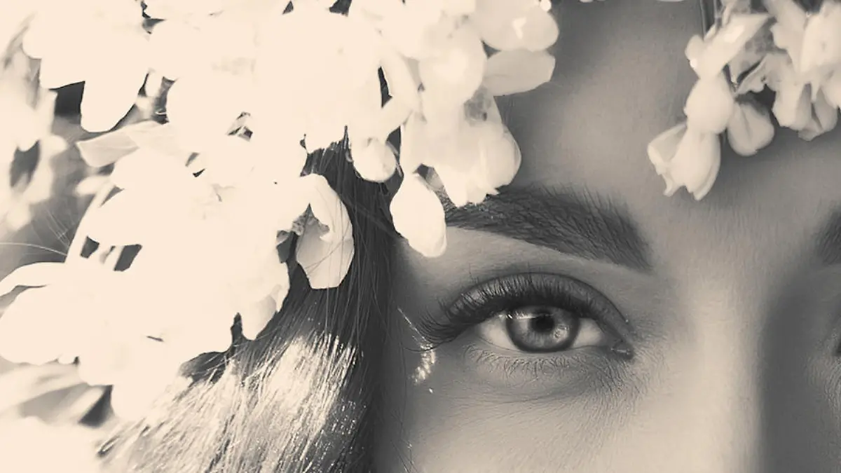 Black and white portrait of beautiful romantic lady in a wreath of apple trees