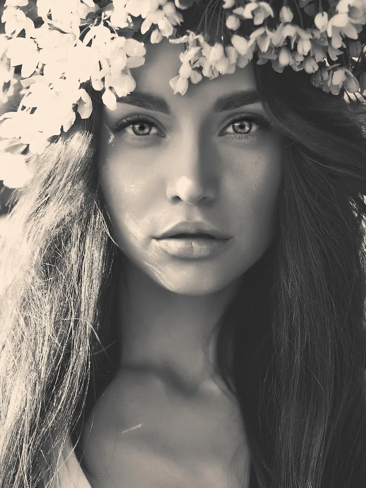 Black and white portrait of beautiful romantic lady in a wreath of apple trees