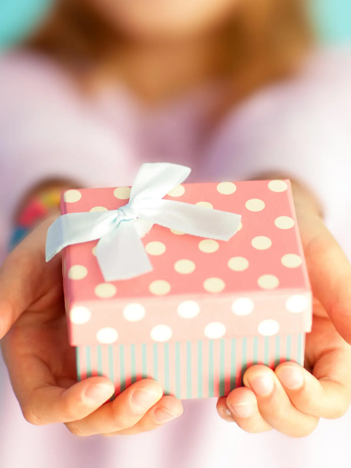 Little girl holding a spotted gift box.