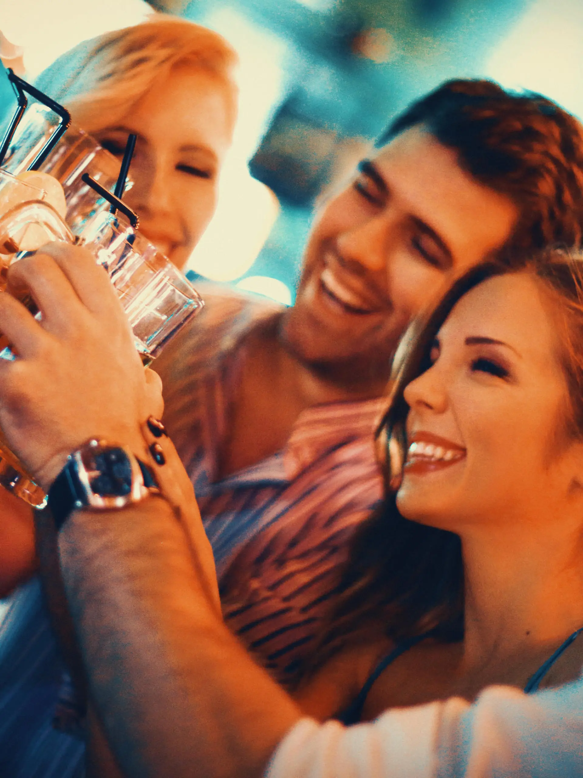 Group of young adult enjoying their night out in a club.Toasting with drinks,laughing and having casual conversation. Two couples on a double date.