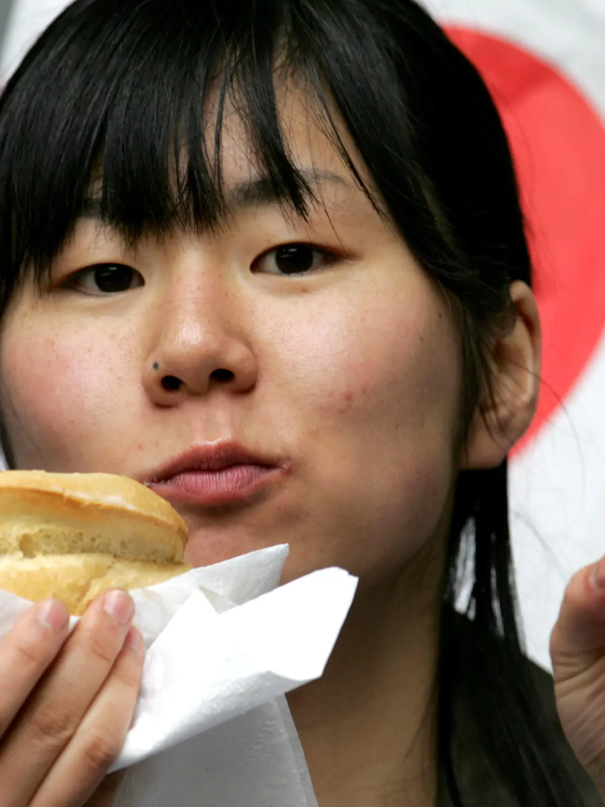 Fußball, Testspiel, Japan - Malta, am Sonntag (04.06.2006) in der LTU-Arena in Düsseldorf. Eine Japanerin isst eine Currywurst und macht das Victory-Zeichen. Foto: Rolf Vennenbernd dpa/lnw +++(c) dpa - Bildfunk+++
