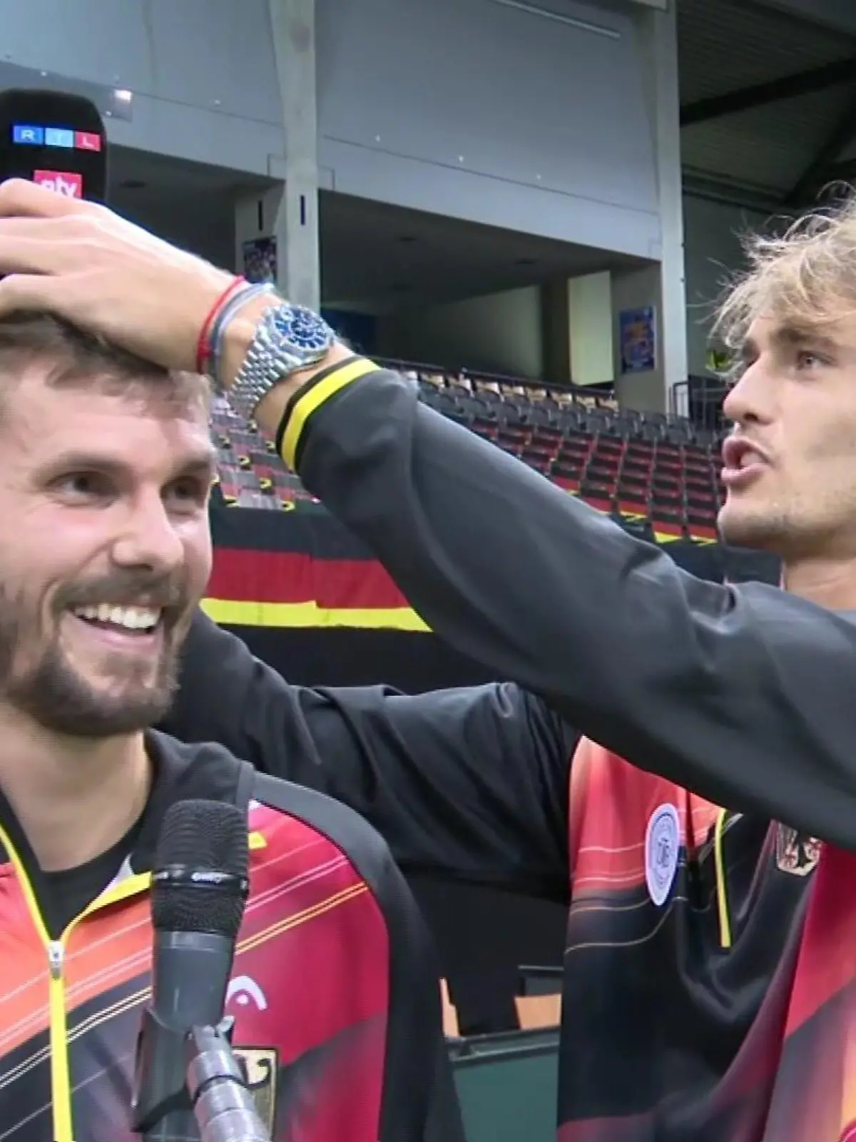Alexander Zverev legt Oscar Otte den RTL-Mikrofon-Winschutz auf den Kopf.