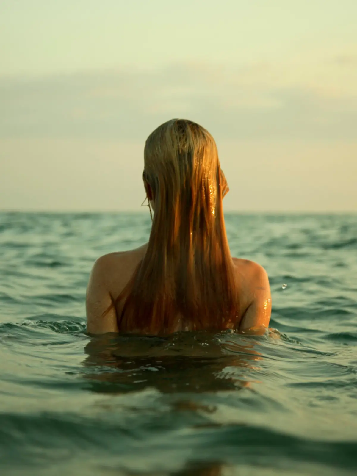 The girl swiming in sea waves. An art photo. A beautiful landscape.