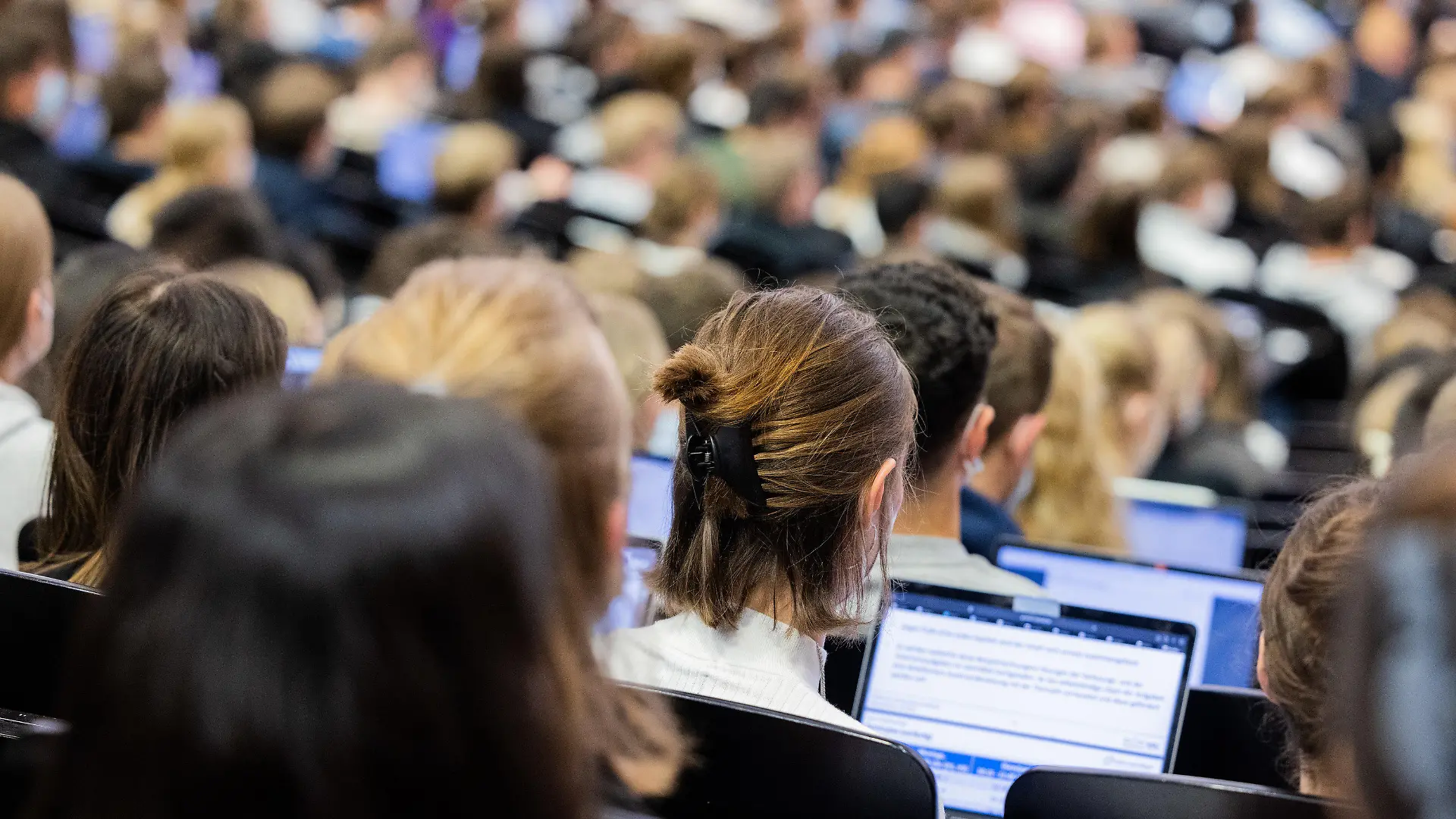 ARCHIV - 11.10.2021, Nordrhein-Westfalen, Münster: Studentinnen und Studenten sitzen während einer Vorlesung in einem der Westfälischen Wilhelms-Universität (WWU). Das Bundeskabinett beschließt in seiner Sitzung am Freitag die Einmalzahlung für Studierende und Fachschüler. Studierende und Fachschüler sollen wegen der explodierenden Preise eine Einmalzahlung von 200 Euro bekommen. Das hatte die Ampel im September vereinbart. Foto: Rolf Vennenbernd/dpa +++ dpa-Bildfunk +++