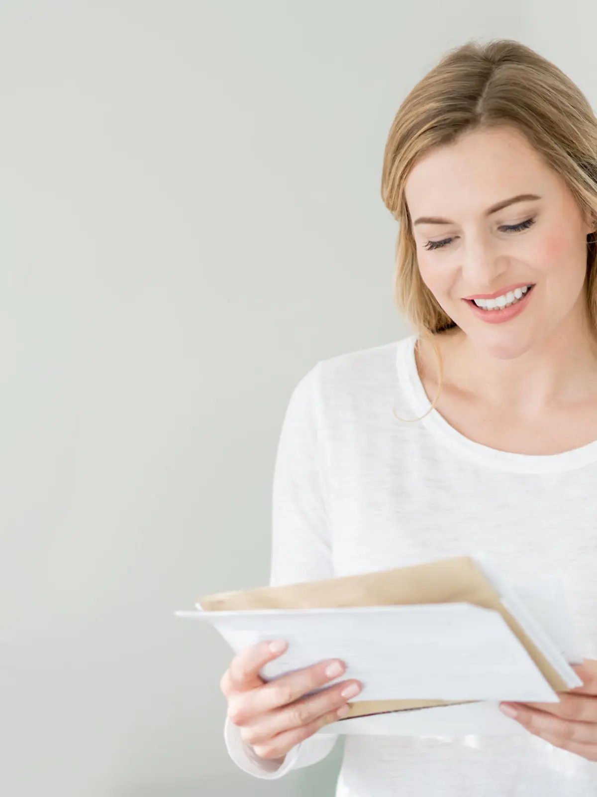 Casual woman at home getting the mail and looking very happy