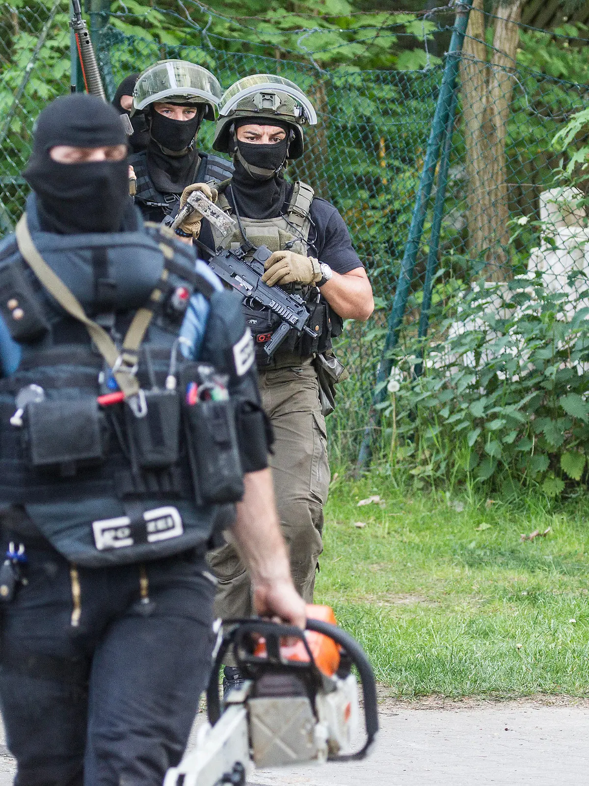 Beamte eines Spezialeinsatzkommandos (SEK) durchsuchen am 18.05.2017 in Berlin eine Gartenkolonie in Heiligensee. In dem Berliner Stadtteil wurde in einem Haus die Leiche einer Frau gefunden. Es handele sich vermutlich um eine Beziehungstat, teilte die Polizei am Donnerstagnachmittag mit. Der Täter war zunächst flüchtig. Foto: Paul Zinken/dpa +++(c) dpa - Bildfunk+++