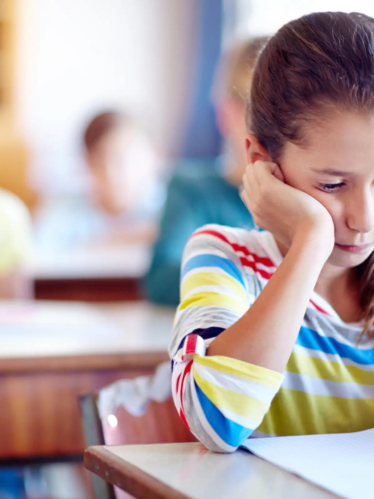 Schülerin sieht verzweifelt und traurig aus. A young girl looking bored in class.