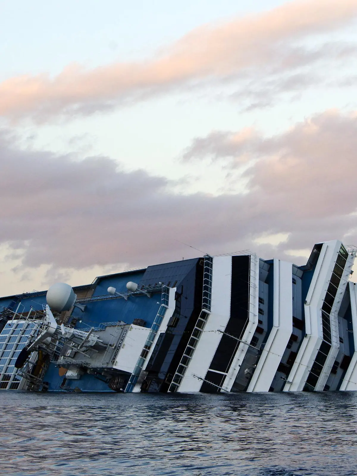 FILE - The wreck of Costa Concordia cruise ship stranded off Giglio Island, Italy, 21 gennaio 2012. Reports state that on 21 January 2012 the underwater search operations resumed amid the wreckage of the cruise liner Costa Concordia, which has been listing off the coast of the Italian island of Giglio ever since it ran aground a week ago. Divers were planning to use explosives to create three holes in deck five, where it is believed missing people may still be. More than 20 of the more than 4,000 passengers are still missing. The official death toll stands at 11. EPA/MASSIMO PERCOSSI (zu dpa:"«Costa Concordia»-Prozess steuert auf Ende zu" vom 09.01.2015) +++(c) dpa - Bildfunk+++