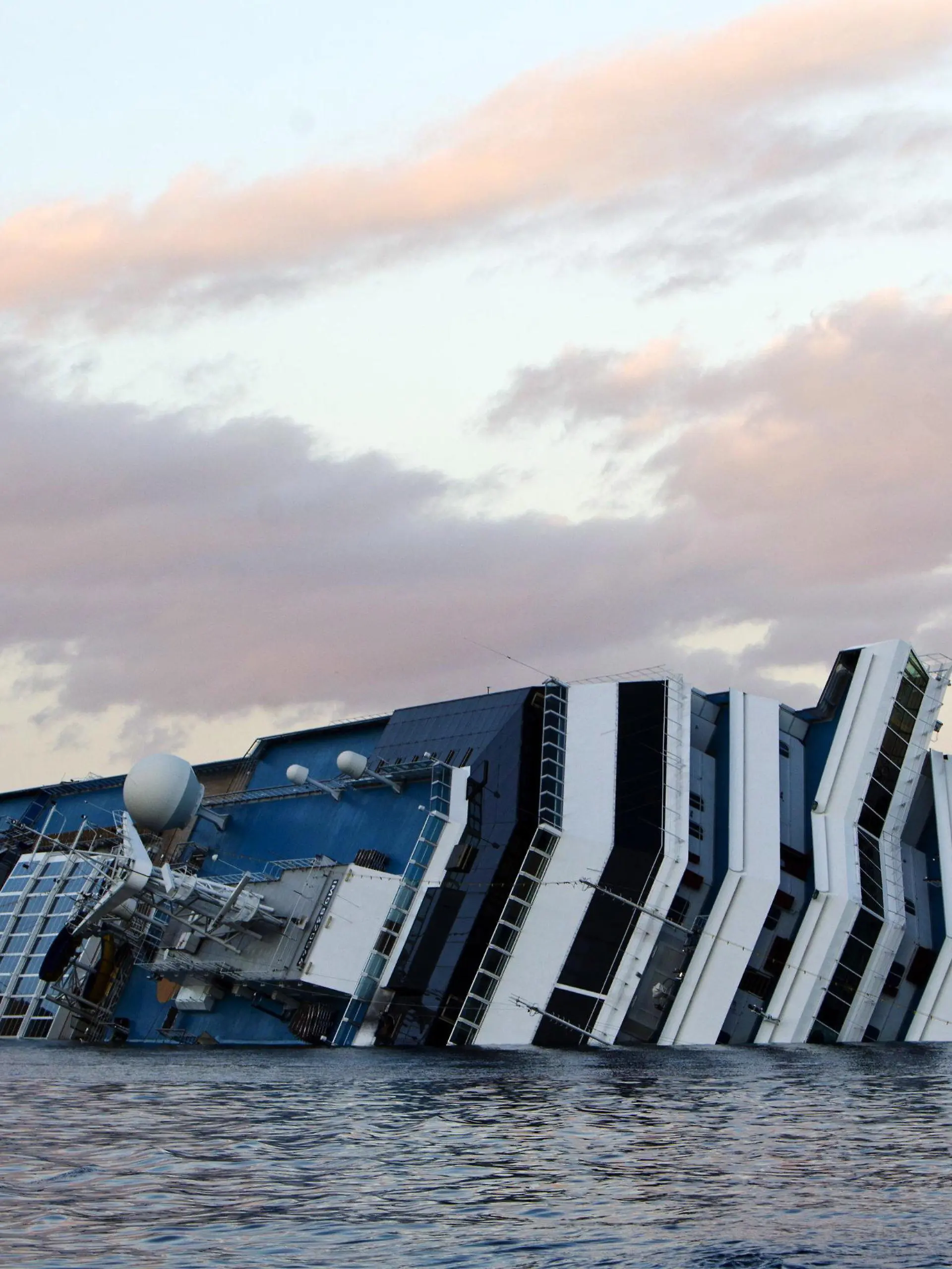 FILE - The wreck of Costa Concordia cruise ship stranded off Giglio Island, Italy, 21 gennaio 2012. Reports state that on 21 January 2012 the underwater search operations resumed amid the wreckage of the cruise liner Costa Concordia, which has been listing off the coast of the Italian island of Giglio ever since it ran aground a week ago. Divers were planning to use explosives to create three holes in deck five, where it is believed missing people may still be. More than 20 of the more than 4,000 passengers are still missing. The official death toll stands at 11. EPA/MASSIMO PERCOSSI (zu dpa:"«Costa Concordia»-Prozess steuert auf Ende zu" vom 09.01.2015) +++(c) dpa - Bildfunk+++