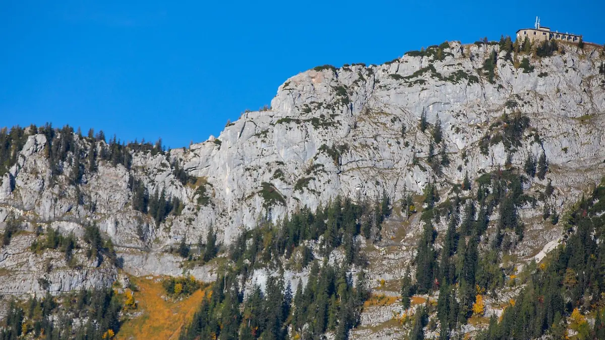 PRODUKTION - 16.06.2023, Bayern, Berchtesgaden: Rechts oben ist das Kehlsteinhaus zu sehen. Die Fahrtstrecke für den Bus verläuft am steilen Berg entlang. Die letzten Meter zum Haus absolvieren Besucher zu Fuß oder mit dem Aufzug.  Die höchstgelegene Busstrecke Deutschlands soll elektrifiziert werden - eine Bewährungsprobe der besonderen Art für die Bustechnik. Über enge Kurven sind am Kehlstein mehr als 700 Höhenmeter zu bewältigen. (Zu dpa «Kehlstein setzt auf Elektrobusse - höchstgelegene Buslinie») Foto: Kilian Pfeiffer/dpa +++ dpa-Bildfunk +++