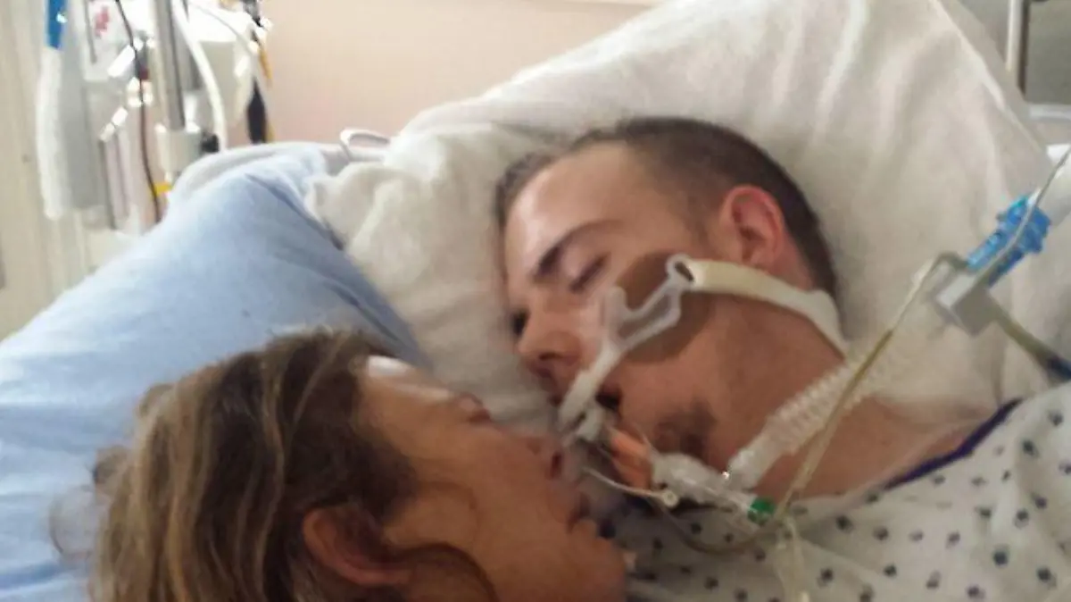 Mutter liegt im Krankenbett mit dem sterbenden Sohn.