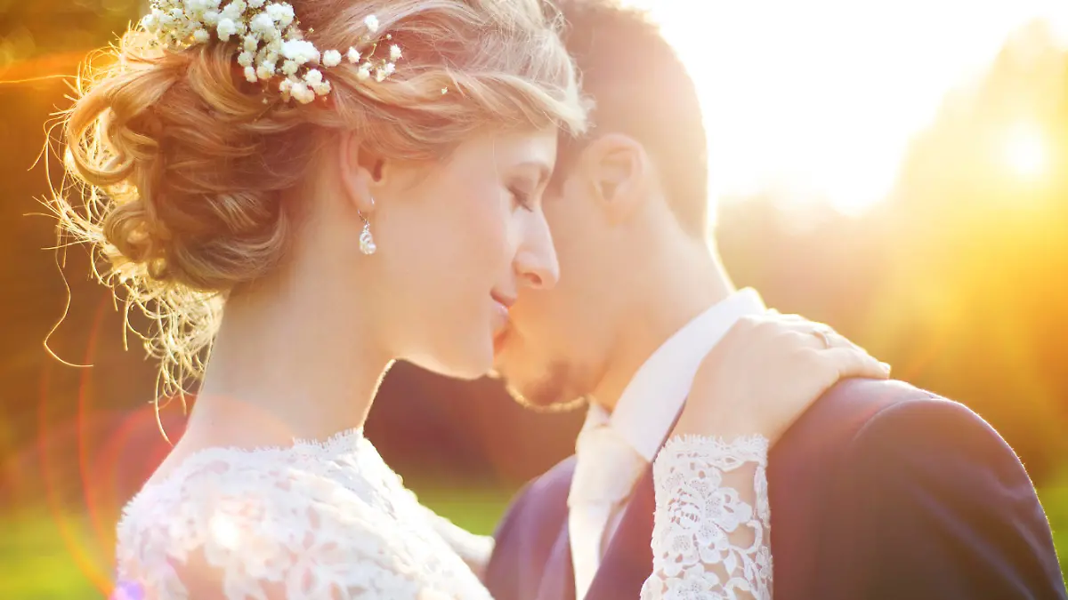 Young wedding couple enjoying romantic moments outside on a summer meadow