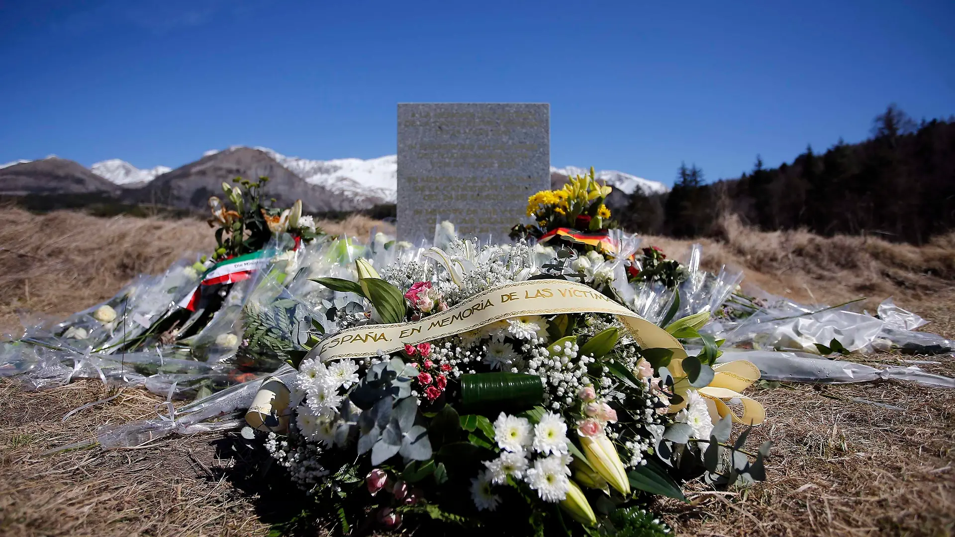 A wreath of flowers to the memory of victims from Spain is seen at the memorial for the victims of the air disaster in the village of Le Vernet, near the crash site of the Airbus A320 in French Alps March 27, 2015. A young German co-pilot barricaded himself alone in the cockpit of Germanwings flight 9525 and apparently set it on course to crash into an Alpine mountain, killing all 150 people on board including himself, French prosecutors said on Thursday. The pilot Andreas Lubitz, 27, who appears to have deliberately crashed a plane carrying 149 others into the French Alps received psychiatric treatment for a "serious depressive episode" six years ago, German tabloid Bild reported on Friday.   REUTERS/Eric Gaillard