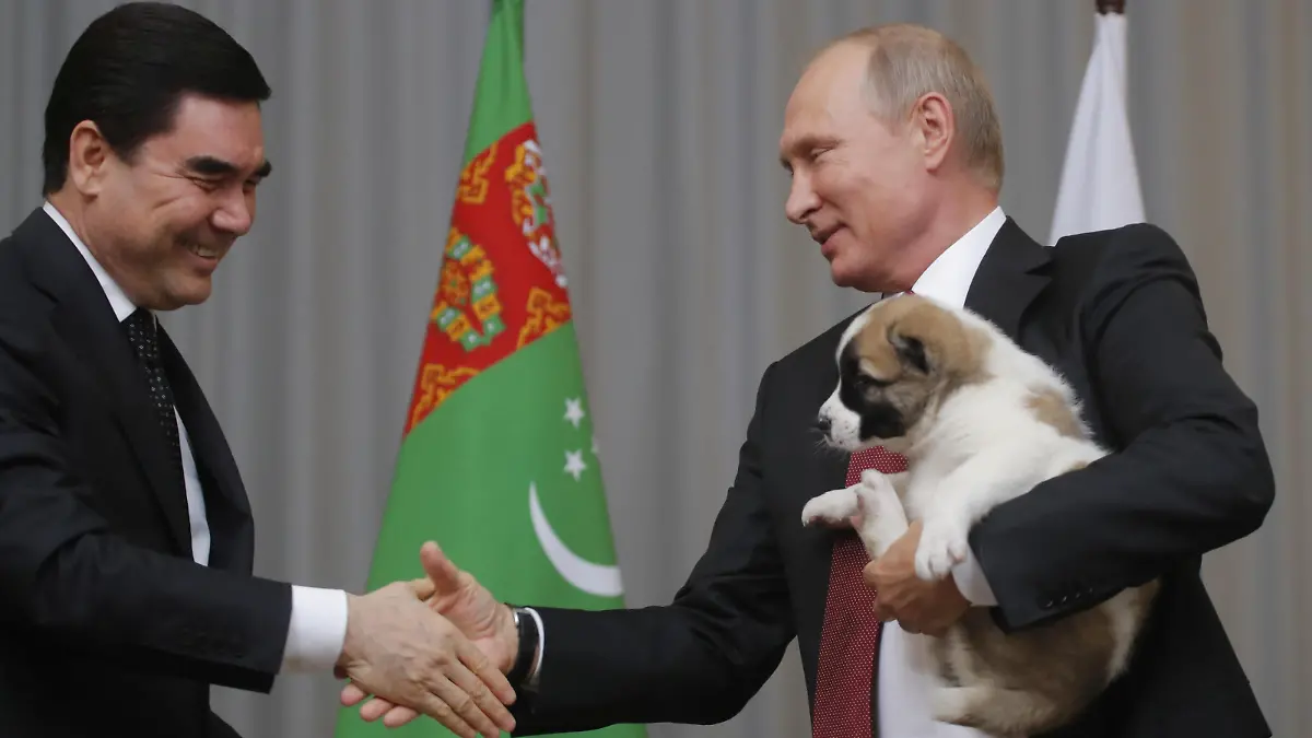 FILE PHOTO: Turkmenistan's President Gurbanguly Berdimuhamedov (L) shakes hands with his Russian counterpart Vladimir Putin after presenting him a Turkmen shepherd dog, locally known as Alabai, during a meeting in Sochi, Russia October 11, 2017. REUTERS/Maxim Shemetov/File Photo