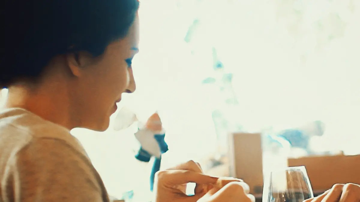 Closeup fo early 30's couple having lunch in a restaurant after shopping. Sitting by window table.They are wearing beige colored casual clothes.