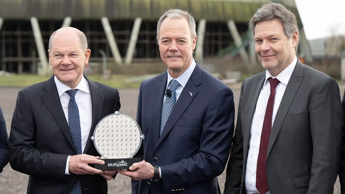 01.02.2023, Saarland, Ensdorf: Bundeskanzler Olaf Scholz (l-r, SPD) und Gregg Lowe, CEO von Wolfspeed, und Robert Habeck (Bündnis 90/Die Grünen), Bundesminister für Wirtschaft und Klimaschutz, halten auf einer Veranstaltung am künftigen Standort der Wolfspeed-Chipfabrik in Ensdorf im Saarland einen Wafer. Der US-Konzern Wolfspeed will im Saarland eine moderne Chipfabrik bauen. Foto: Boris Roessler/dpa +++ dpa-Bildfunk +++