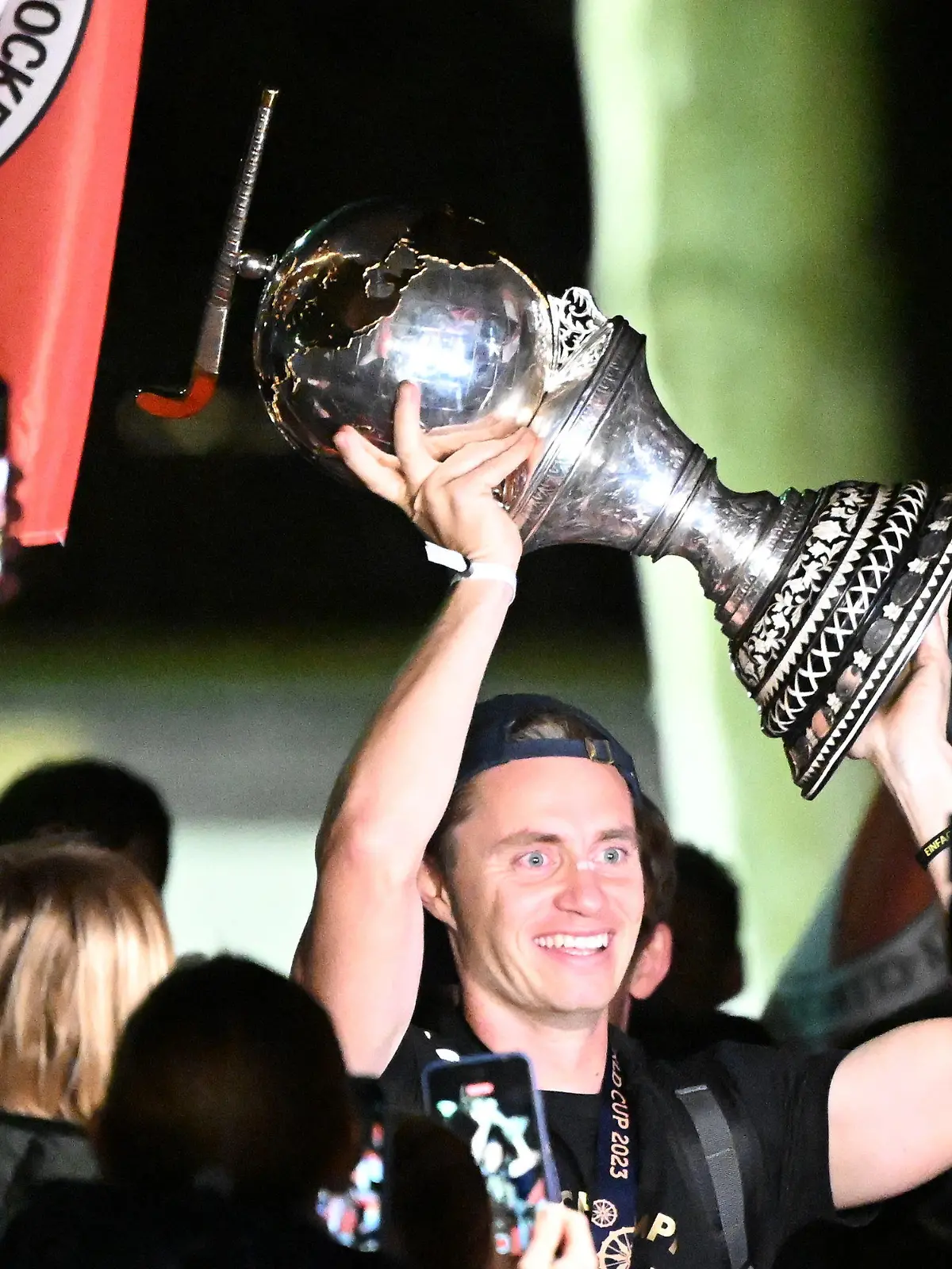 31.01.2023, Nordrhein-Westfalen, Köln: Hockey, Herren: Ankunft der deutschen Nationalmannschaft nach dem WM-Triumph. Kapitän Mats Grambusch (M) hebt den Weltmeister-Pokal in die Höhe. Die Weltmeister-Mannschaft feiert mit den Fans beim Kölner Tennis- und Hockey Club Rot-Weiss. Foto: Federico Gambarini/dpa +++ dpa-Bildfunk +++