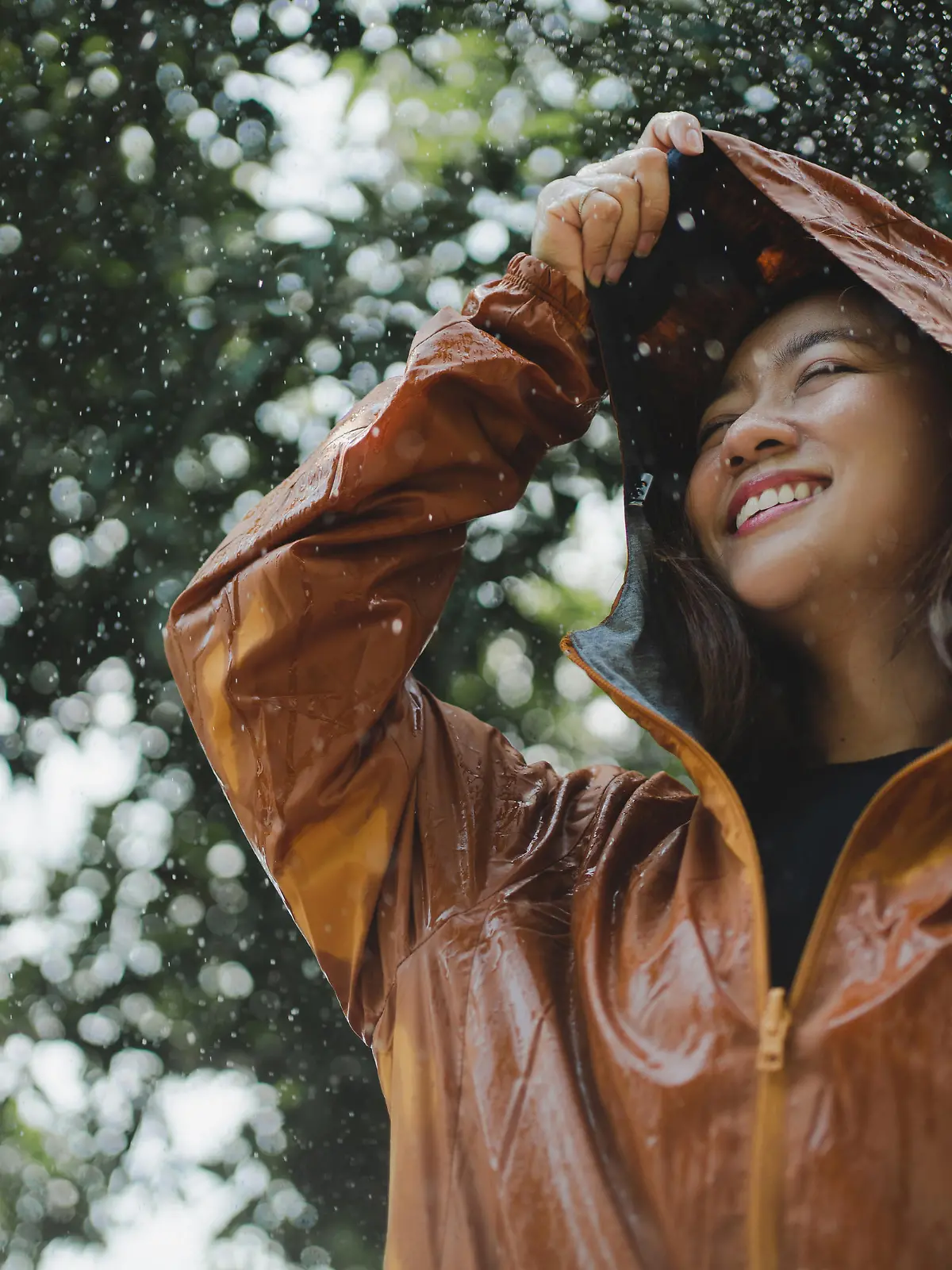 Asian woman is outdoors while it's raining. She felt refreshed.