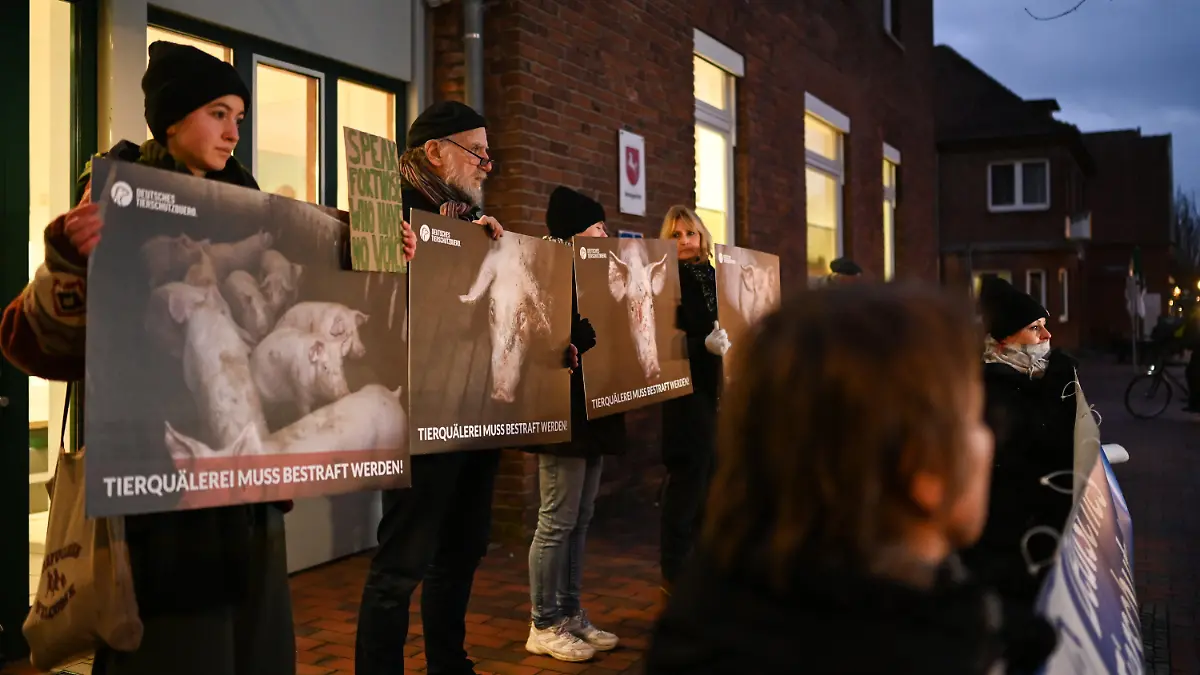 31.01.2023, Niedersachsen, Papenburg: Demonstranten stehen bei einem Protest des Deutschen Tierschutzbüros gegen Tierquälerei vor dem Amtsgericht. Im Zusammenhang mit Tierschutzverstößen in einer Schweinemast im Emsland müssen sich zwei Angeklagte vor dem Amtsgericht Papenburg verantworten. Foto: Lars Klemmer/dpa +++ dpa-Bildfunk +++