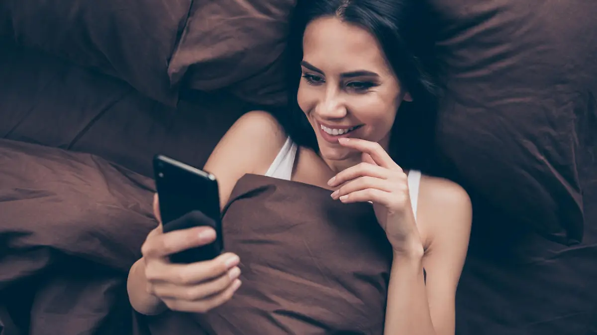 Top above high angle view close-up portrait of her she nice attractive, lovely flirt charming cute cheerful cheery girl using gadget sending photos lying in bed in room flat house indoors