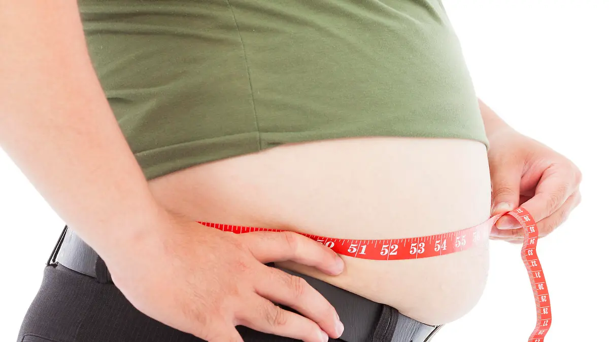 fat man use scale to measure his waistline in studio