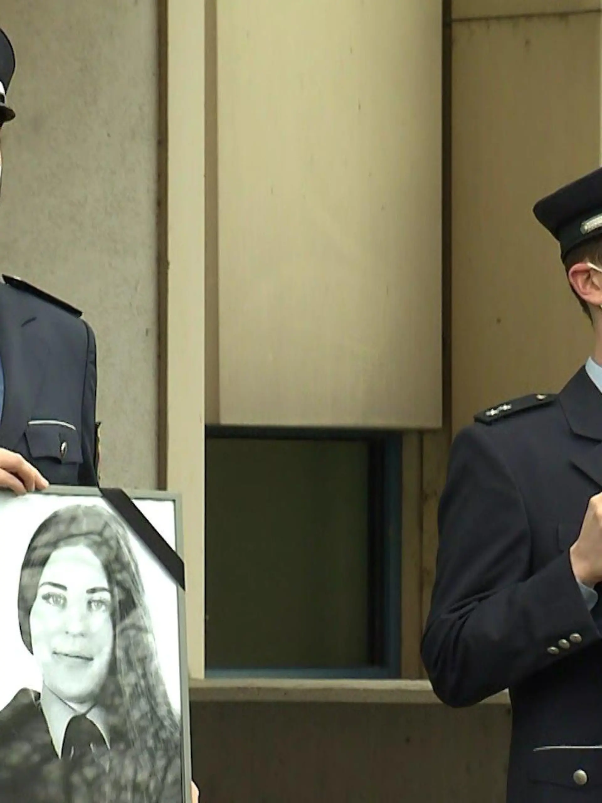 Zwei Polizisten halten die Bilder der beiden ermordeten Polizeibeamten in die Luft.
