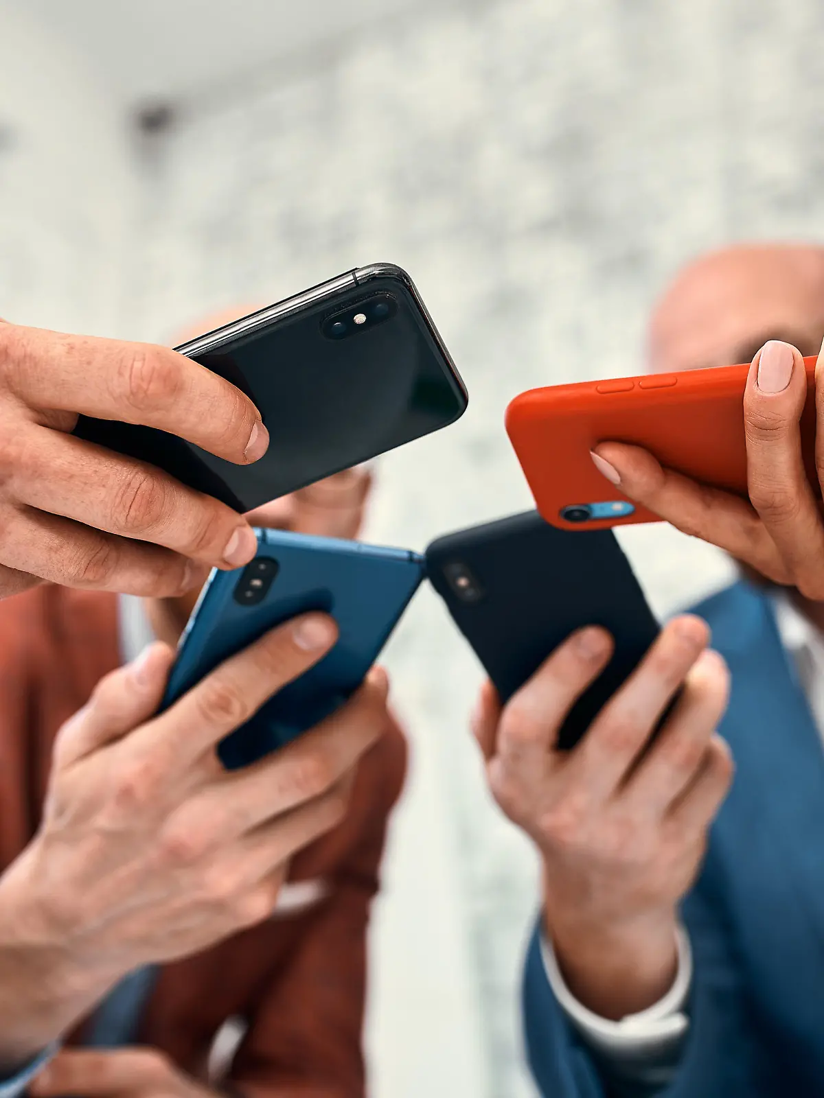 Male and female diverse hands holding cell phones, multiracial business people using smartphones applications software, users and devices concept, mobile communication.