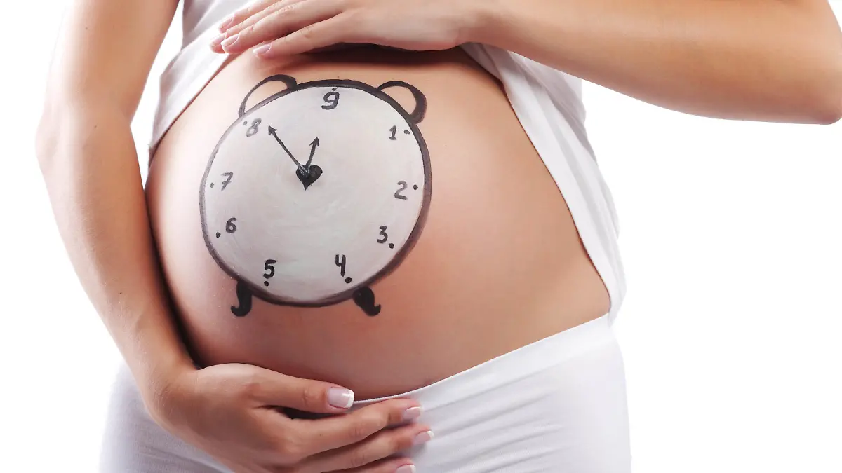 Conceptual image of pregnant belly with painted clock, Begriffsimage des schwangeren Bauchs mit der gemalten Uhr Keine Weitergabe an Drittverwerter.
