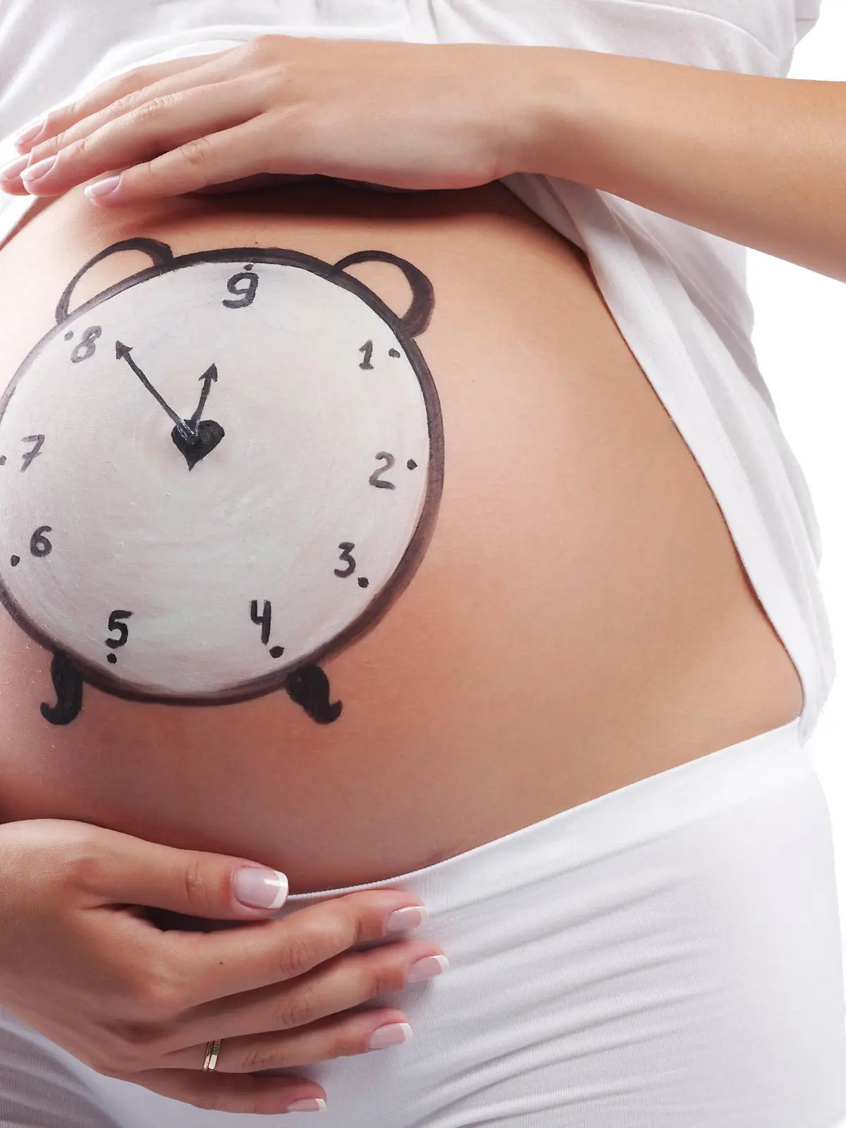 Conceptual image of pregnant belly with painted clock, Begriffsimage des schwangeren Bauchs mit der gemalten Uhr Keine Weitergabe an Drittverwerter.