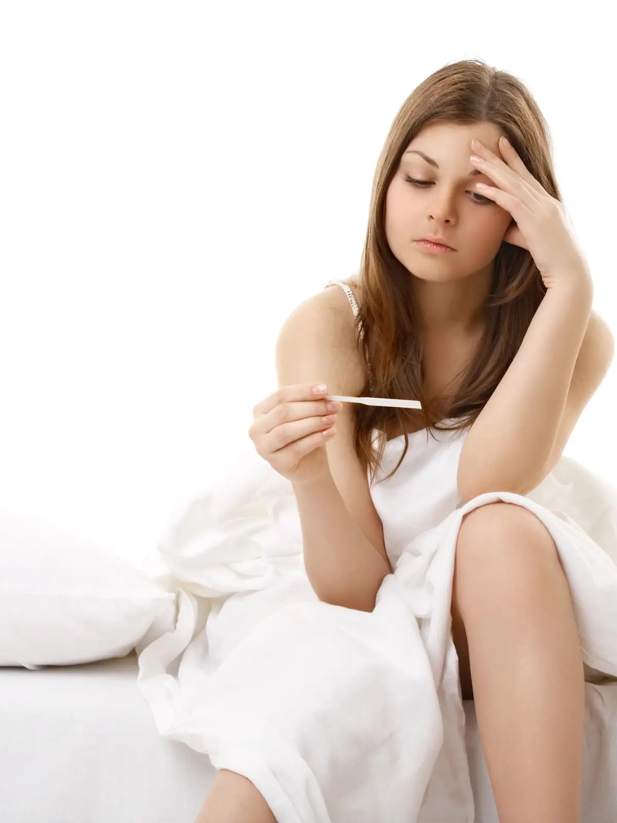The afflicted girl sits in bed and sees result of the test for pregnancy

