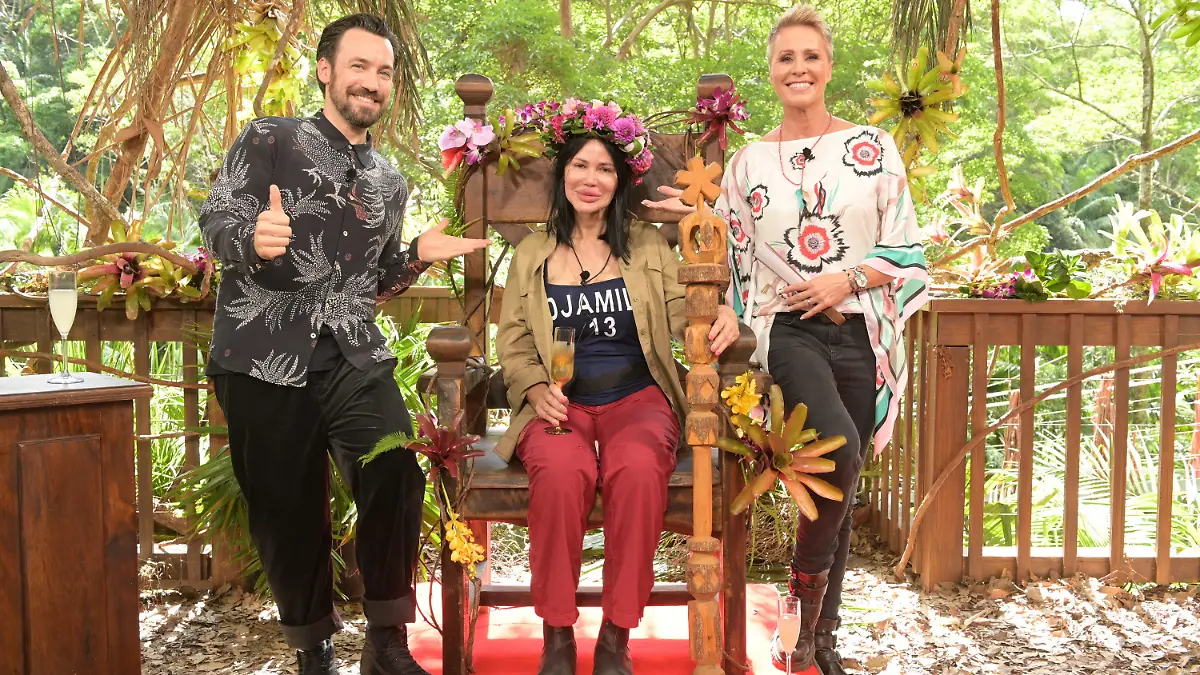 30.01.2023, Australien, Brisbane: Visagistin Djamila Rowe sitzt mit ihrer Krone nach dem Sieg beim RTL-Dschungelcamp 2023 auf ihrem Thron neben der Moderatorin Sonja Zietlow (r) und Moderator Jan Köppen. Die Visagistin und Reality-TV-Kandidatin Djamila Rowe hat das RTL-Dschungelcamp 2023 gewonnen. Foto: Stefan Thoyah/RTL/dpa - ACHTUNG: Nur zur redaktionellen Verwendung im Zusammenhang mit einer Berichterstattung über das Dschungelcamp 2023 und nur mit vollständiger Nennung des vorstehenden Credits +++ dpa-Bildfunk +++
