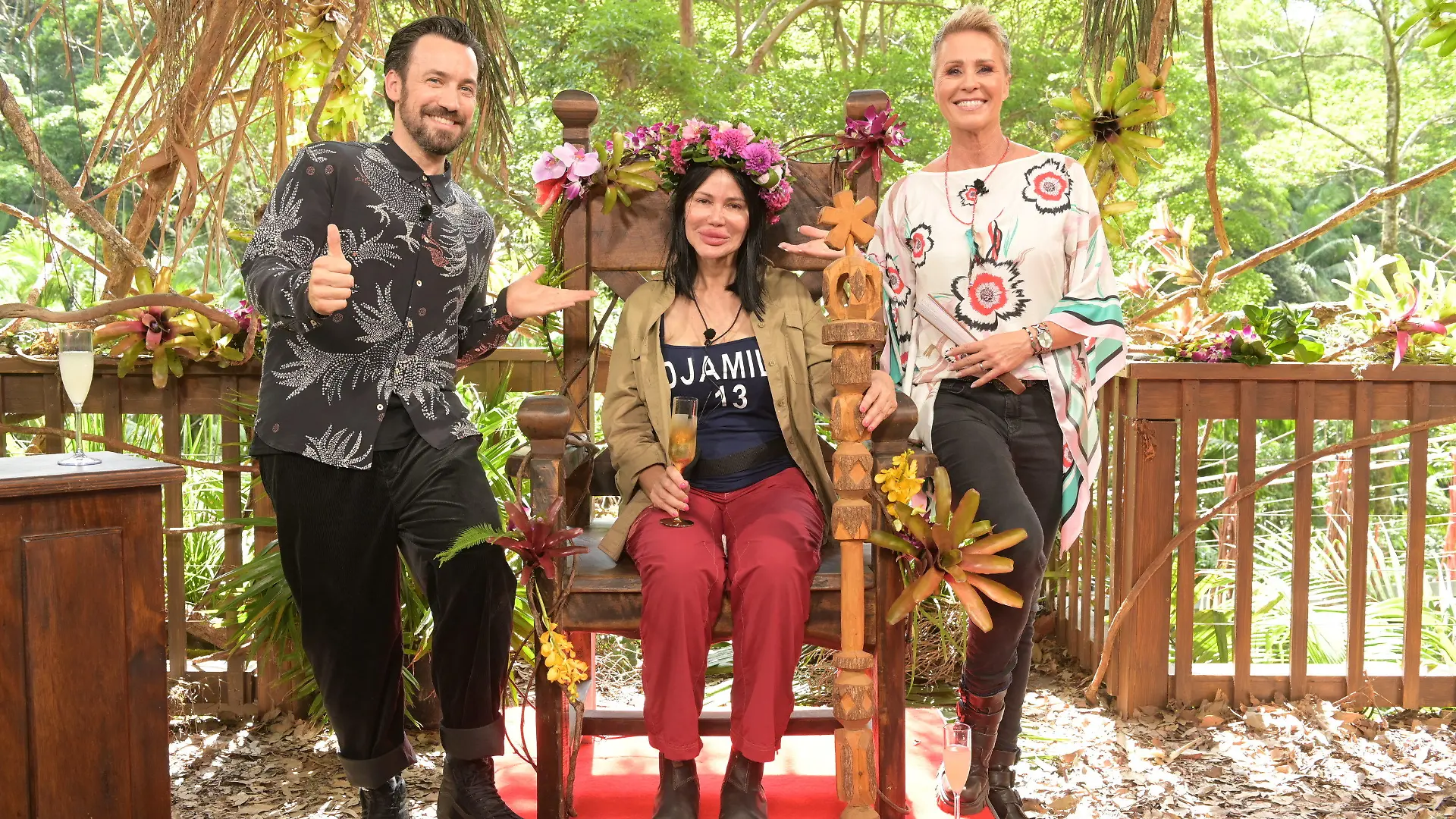 30.01.2023, Australien, Brisbane: Visagistin Djamila Rowe sitzt mit ihrer Krone nach dem Sieg beim RTL-Dschungelcamp 2023 auf ihrem Thron neben der Moderatorin Sonja Zietlow (r) und Moderator Jan Köppen. Die Visagistin und Reality-TV-Kandidatin Djamila Rowe hat das RTL-Dschungelcamp 2023 gewonnen. Foto: Stefan Thoyah/RTL/dpa - ACHTUNG: Nur zur redaktionellen Verwendung im Zusammenhang mit einer Berichterstattung über das Dschungelcamp 2023 und nur mit vollständiger Nennung des vorstehenden Credits +++ dpa-Bildfunk +++