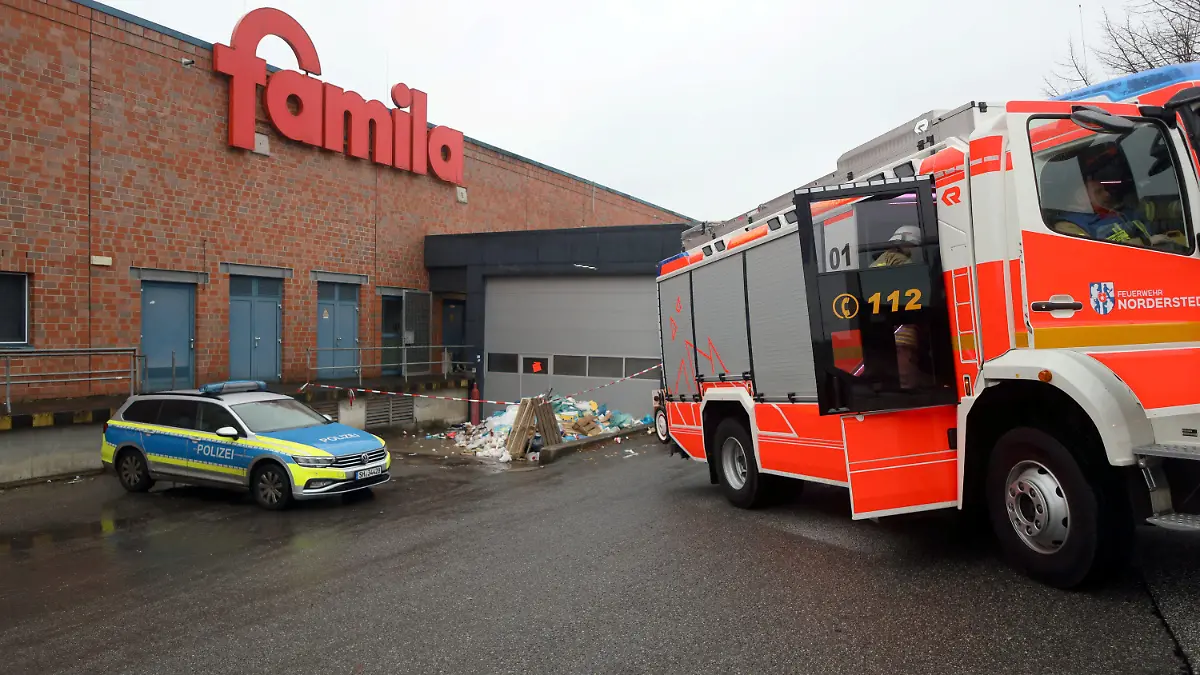 29.01.2023, Schleswig-Holstein, Norderstedt: Feuerwehr und Polizei sind vor der Müllpresse eines Supermarkts im Einsatz. Ein 69 Jahre alter Mann ist am Sonntag tot in einer Müllpresse an einem Supermarkt in Norderstedt entdeckt worden. Der Mann sei am Morgen von seiner Familie als vermisst gemeldet worden, sagte eine Polizeisprecherin. Wie es zu dem Unglücksfall gekommen sei, könne noch nichts gesagt werden. Die Kriminalpolizei habe die Ermittlungen aufgenommen. Foto: Florian Büh/dpa +++ dpa-Bildfunk +++