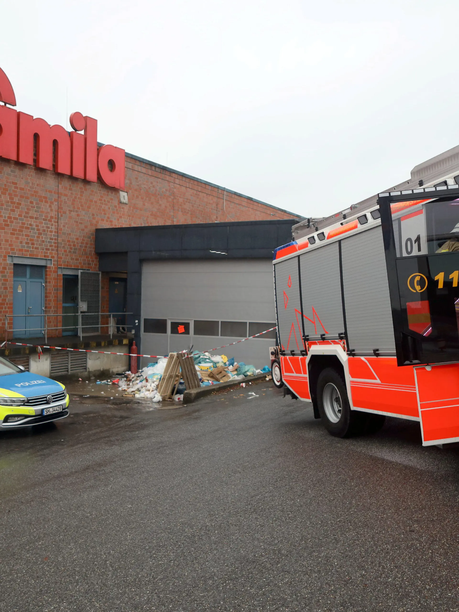 29.01.2023, Schleswig-Holstein, Norderstedt: Feuerwehr und Polizei sind vor der Müllpresse eines Supermarkts im Einsatz. Ein 69 Jahre alter Mann ist am Sonntag tot in einer Müllpresse an einem Supermarkt in Norderstedt entdeckt worden. Der Mann sei am Morgen von seiner Familie als vermisst gemeldet worden, sagte eine Polizeisprecherin. Wie es zu dem Unglücksfall gekommen sei, könne noch nichts gesagt werden. Die Kriminalpolizei habe die Ermittlungen aufgenommen. Foto: Florian Büh/dpa +++ dpa-Bildfunk +++