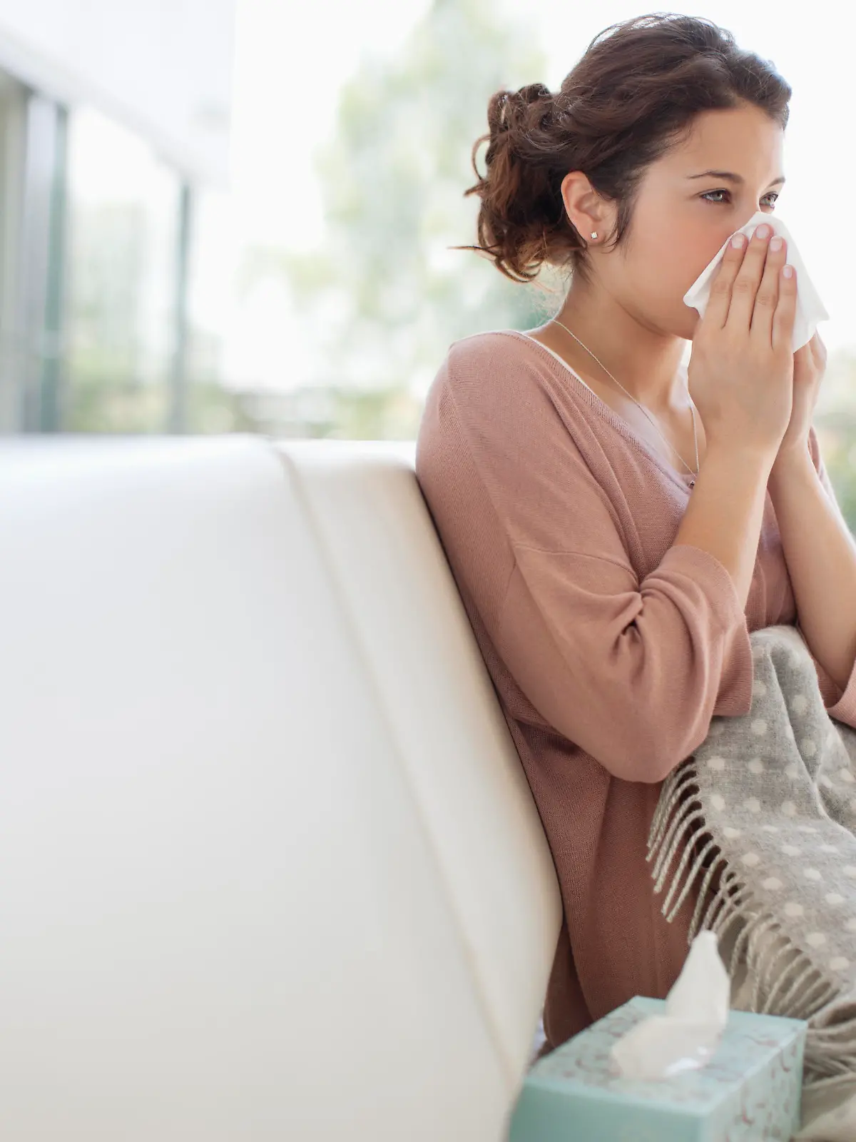 Sick woman blowing her nose