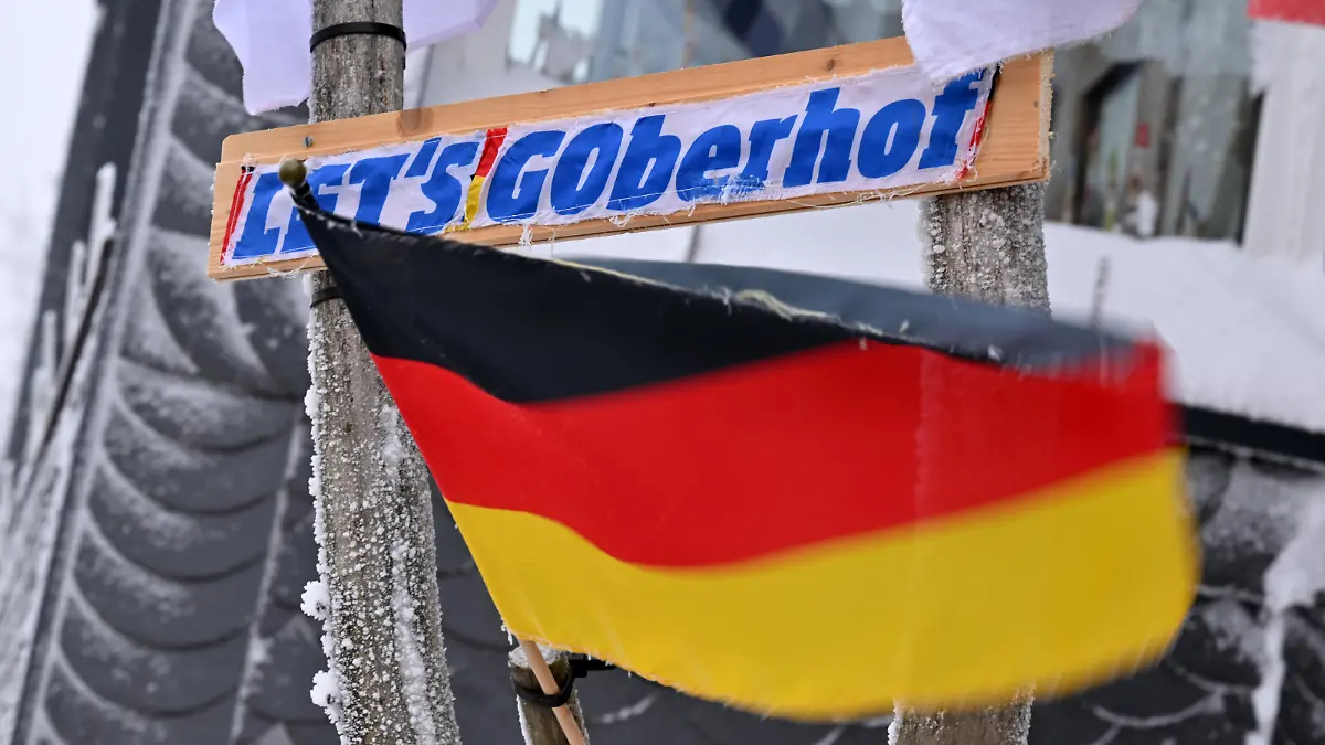 "LET'S GOberhof" steht auf dem Schild neben einer Deutschlandfahne an einem Hauseingang in Oberhof. Die Saisonhöhepunkte im Biathlon- und Rodelsport werden 2023 in Oberhof ausgetragen. Die 51. FIL Rennrodel Weltmeisterschaft findet vom 27. bis 29. Januar statt, die 53. IBU Biathlon Weltmeisterschaft vom 8. bis zum 19. Februar.