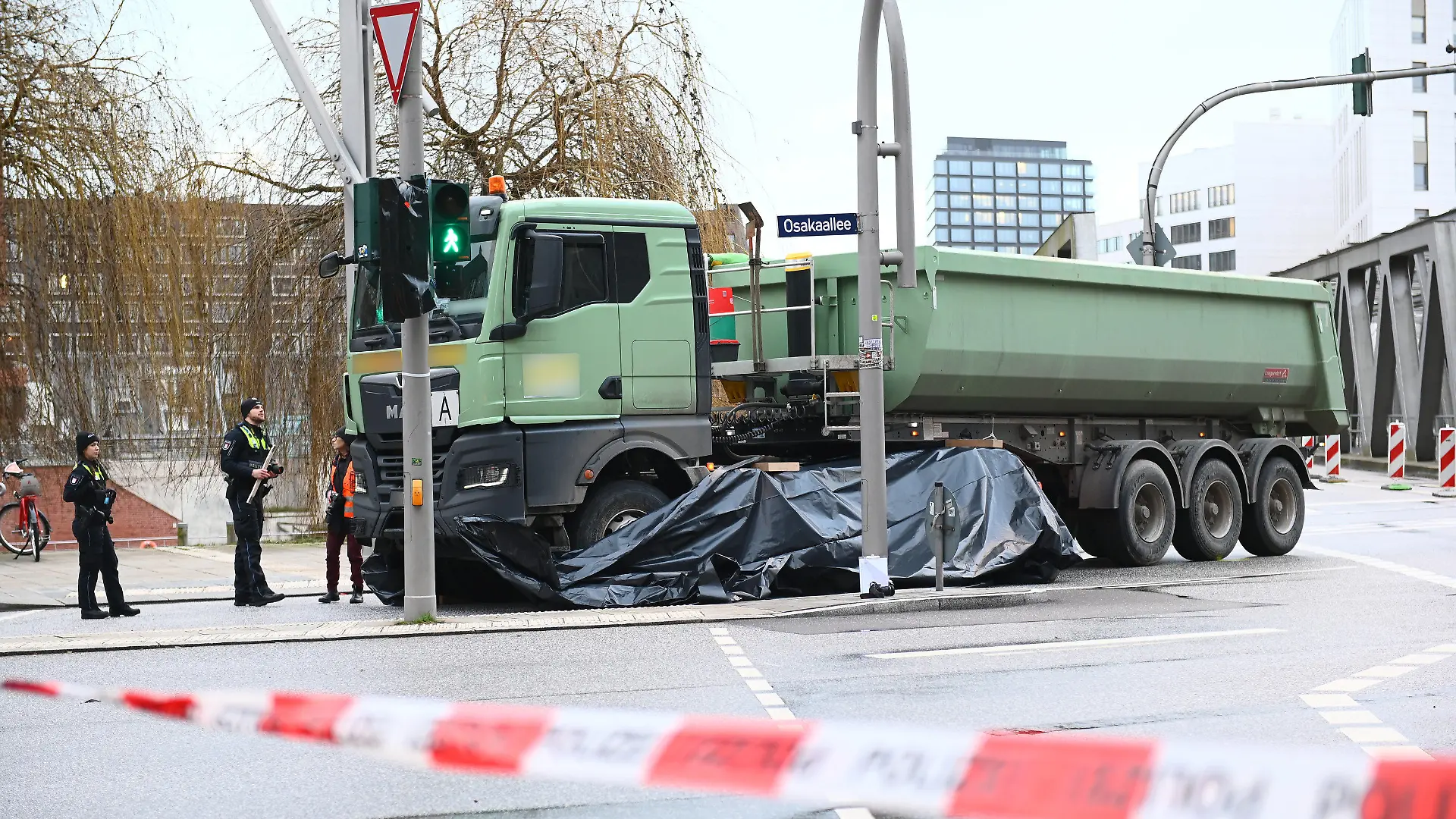 30.01.2023, Hamburg: Polizisten ermitteln am abgesperrten Unfallort. Bei einem Unfall in der Hamburger Hafencity ist am Montag eine Radfahrerin tödlich verletzt worden. Foto: Jonas Walzberg/dpa +++ dpa-Bildfunk +++