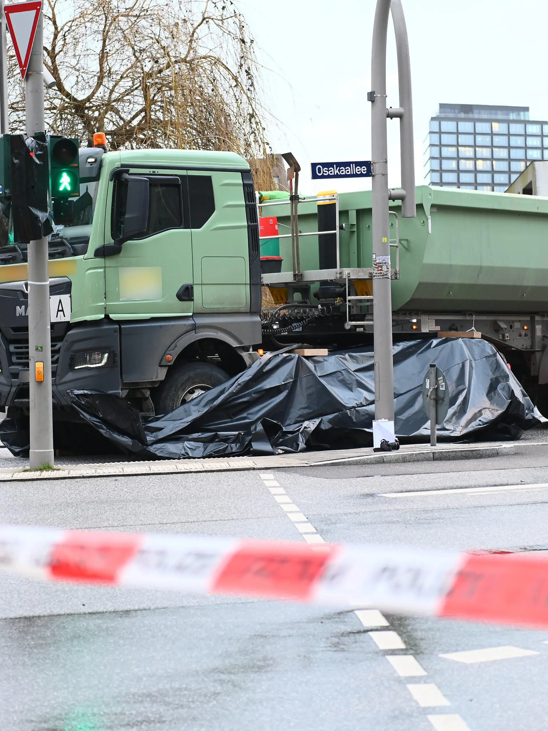 30.01.2023, Hamburg: Polizisten ermitteln am abgesperrten Unfallort. Bei einem Unfall in der Hamburger Hafencity ist am Montag eine Radfahrerin tödlich verletzt worden. Foto: Jonas Walzberg/dpa +++ dpa-Bildfunk +++