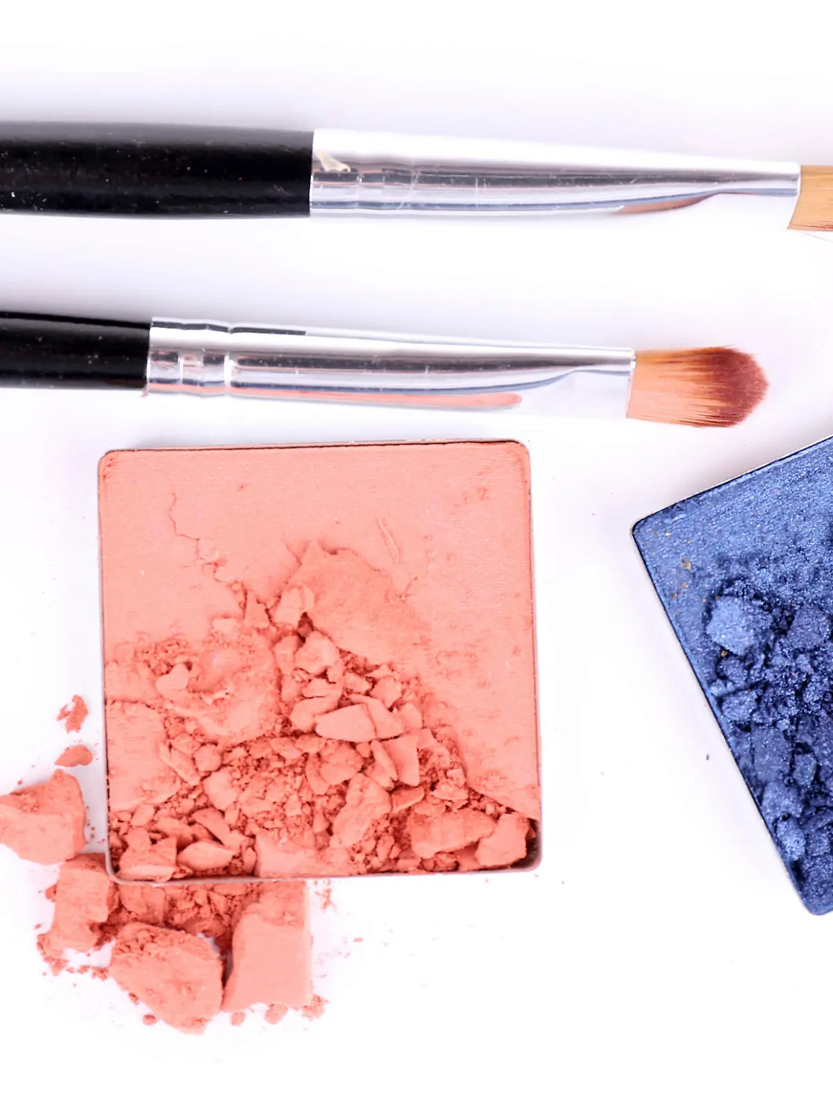 Crushed eyeshadow with brush isolated on white