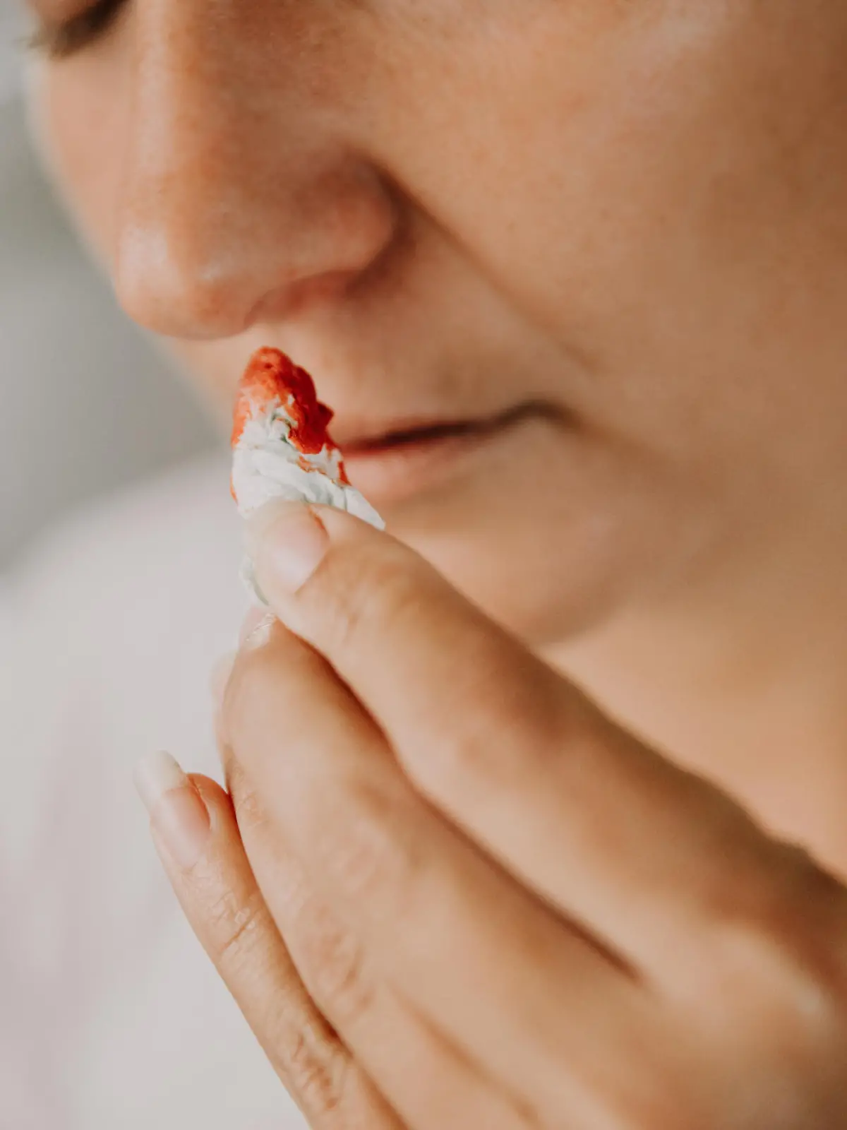 Woman wiping her bleeding nose with tissue
