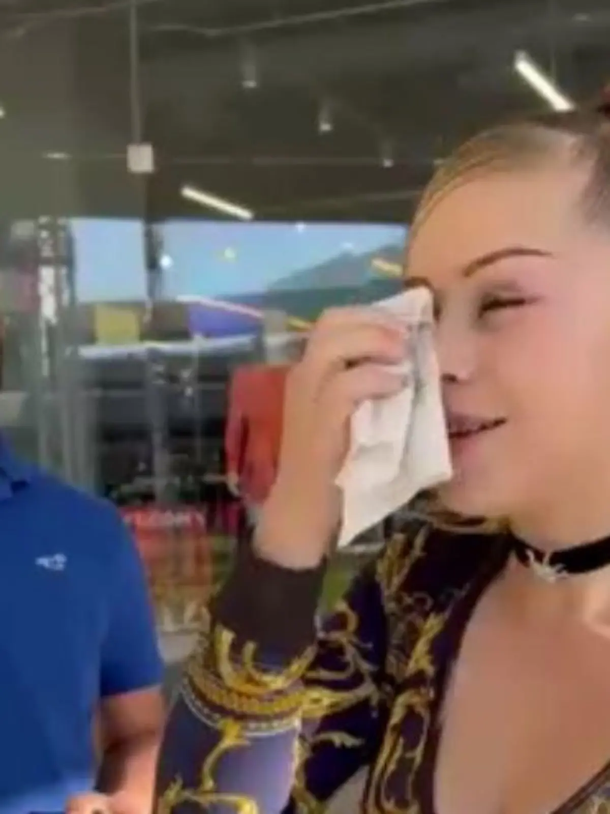 Mann und Frau stehen nebeneinander. Sie schminkt sich ab, er guckt skeptisch