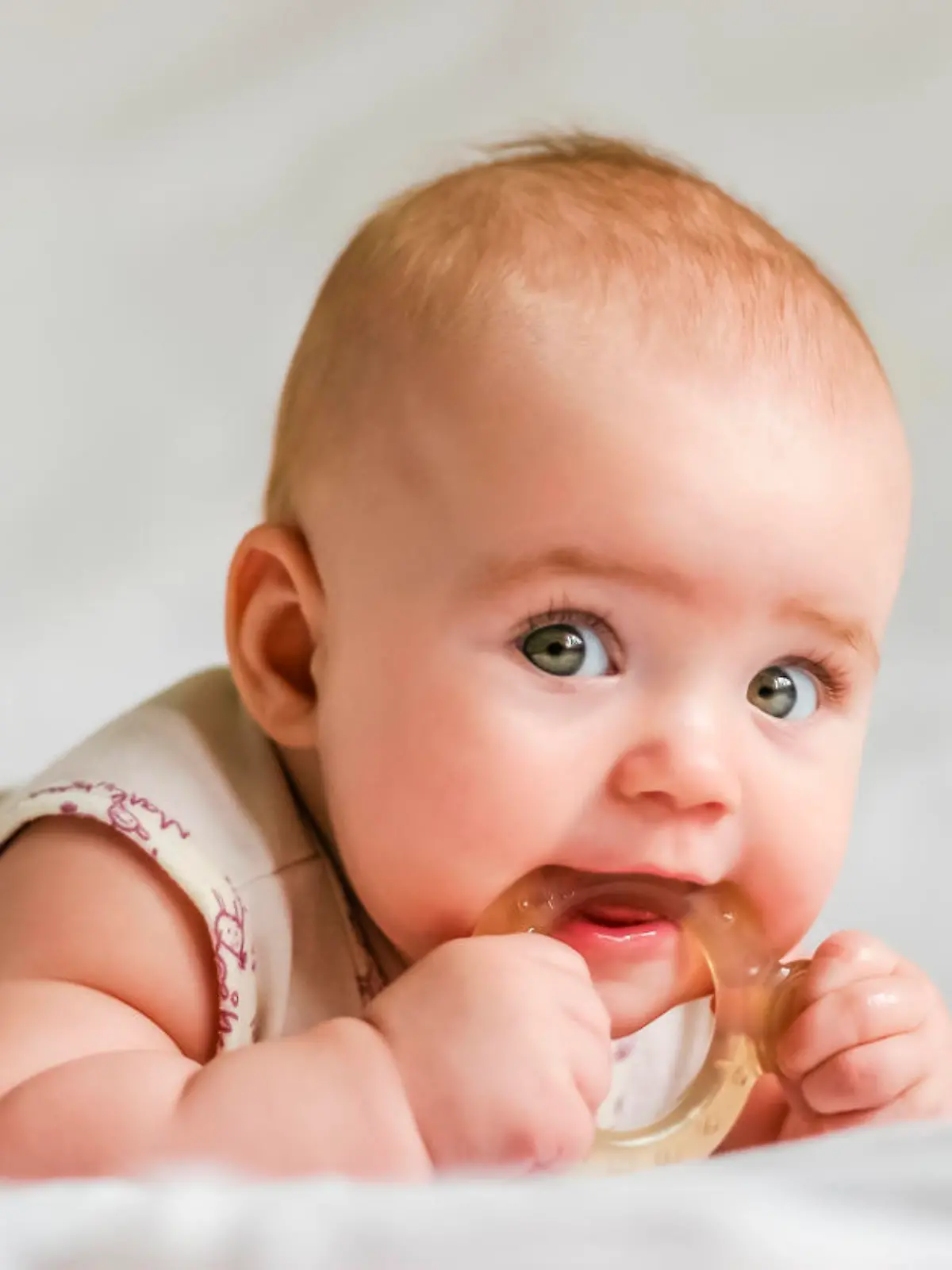 Ein Baby kaut auf einem Beißring.