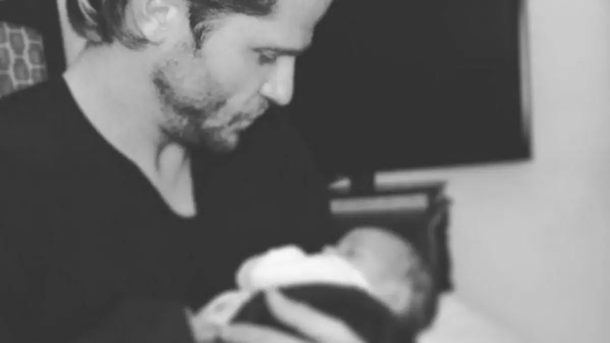 Paul Janke mit dem Baby seines Freundes auf dem Arm