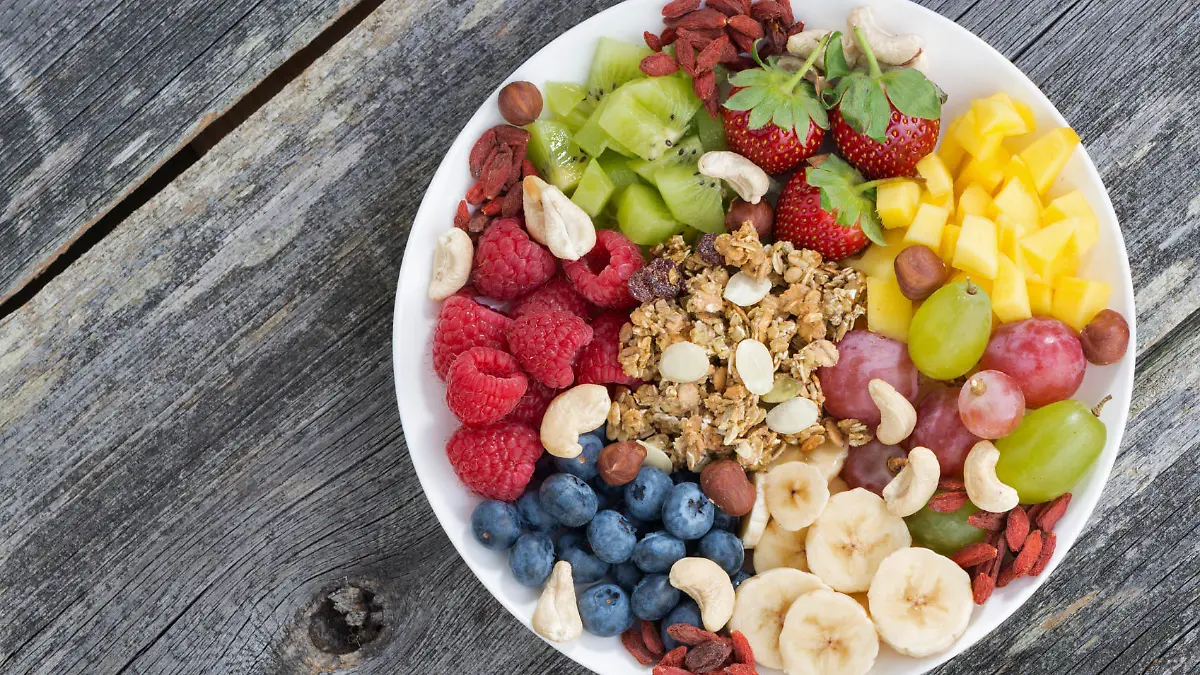 ingredients for a healthy breakfast in one dish on wooden background, top view