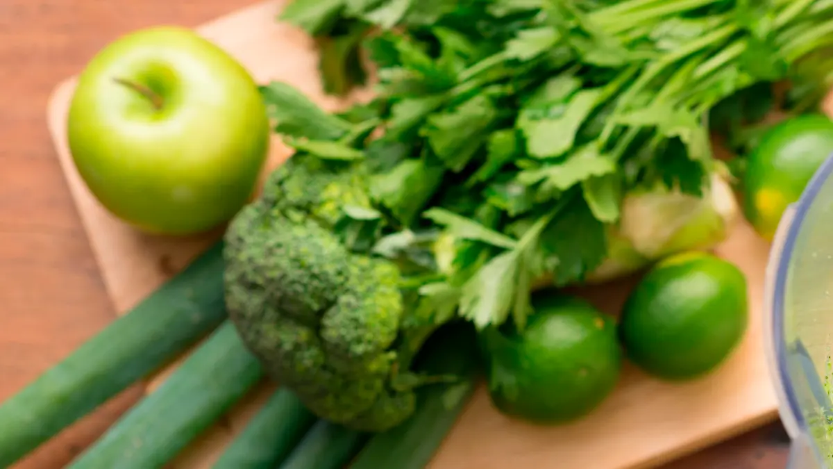 Green smoothie in a blender and ingredients, view from above