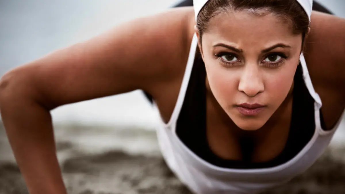 A beautiful asian woman doing push up at a beach