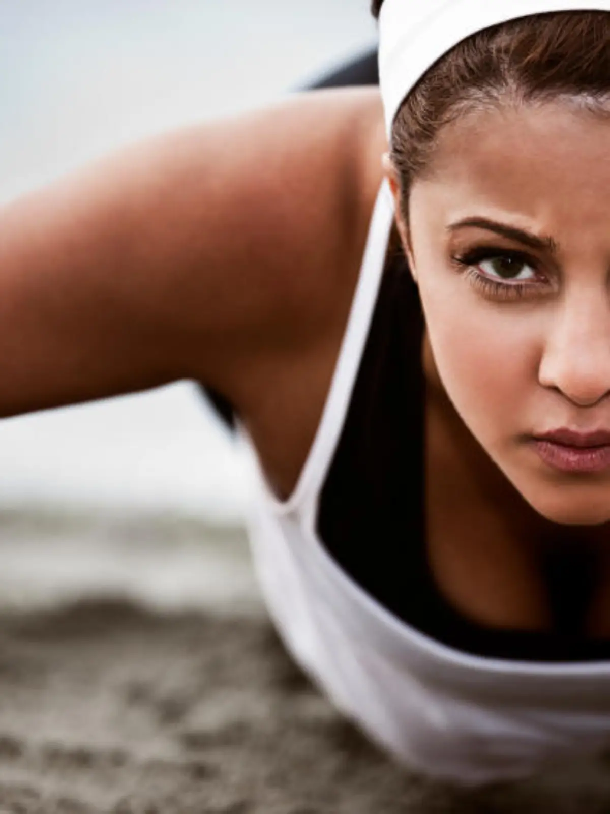 A beautiful asian woman doing push up at a beach