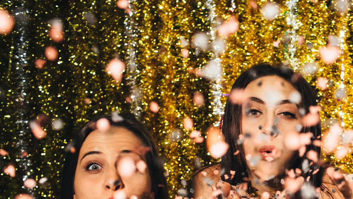 Friends blowing confetti on New Year's Eve - 2016.